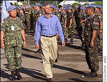 As Chief of UNTAET Sergio Vierra de Mello, center, inspects U.N. peacekeeper troops during his farewell ceremony in Dili, questions remain unanswered about the murdered newsmen