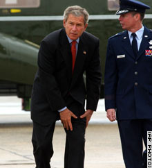President Bush holds his leg as he is escorted from Marine One to Air Force One Thursday.