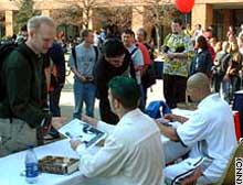 World Wrestling Entertainment (WWE) stars the Hurricane, left, and the Maven sign autographs following a 