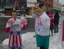 Leslie Gabriel, left, prepares to pound a blow-up bag depicting President Bush in Manchester, New Hampshire.