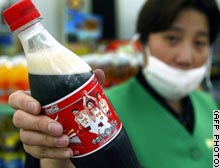 A Shanghai shop assistant shows a Coke bottle featuring Yao Ming's image.