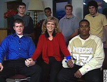 Debbie Schultz (center) holds hands with students Austin Hutchinson (left) and John Bailey (right). Her other students can be seen in the background.