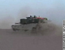 An M1A1 Abrams tank races across the Iraqi desert Friday morning.