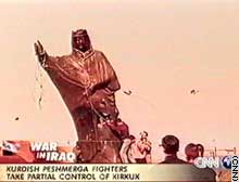 The statue of Saddam in tribal clothes topples in Kirkuk.