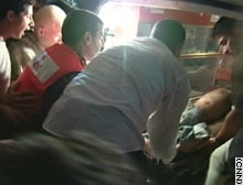Palestinian rescue workers unload an injured man from an ambulance after Sunday's rocket attack in Gaza.