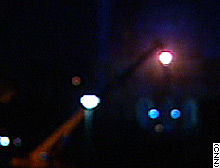 A nighttime view of the cranes placing large concrete barriers to protect the Palestine Hotel.